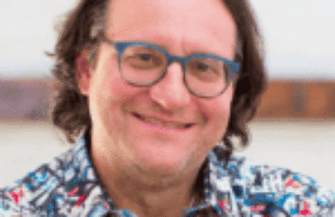 a man with long hair wearing glasses