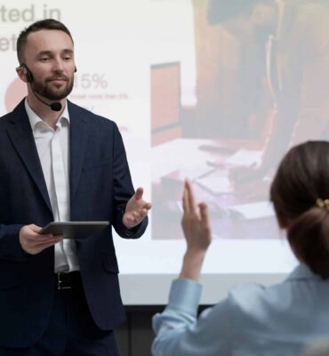 a man in a suit giving a presentation to a woman