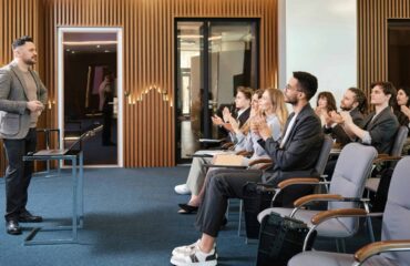 a group of people sitting in chairs clapping